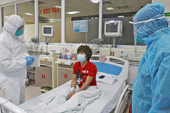 Bác sĩ trò chuyện với bệnh nhân COVID-19 thứ 87, nữ điều dưỡng 34 tuổi là nhân viên tiếp đón tại khu cách ly, Trung tâm Bệnh nhiệt đới thuộc Bệnh viện Bạch Mai, trong phòng điều trị cách ly. Ảnh: Vietnamnet.