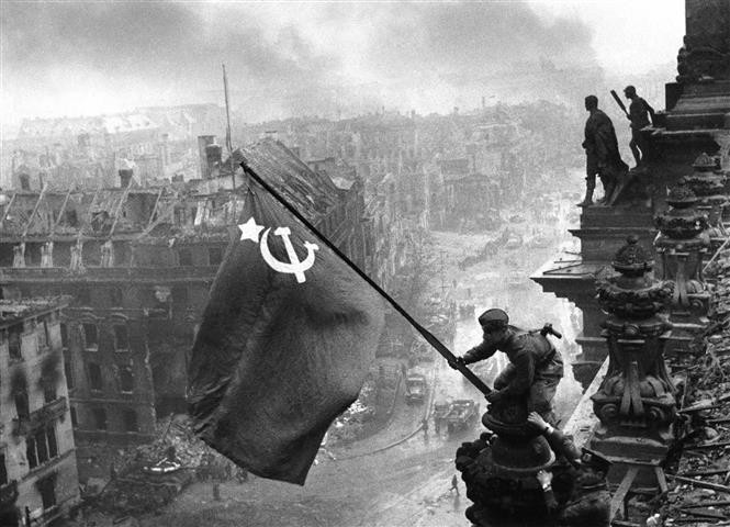 Từ ngày 16/4 – 2/5/1945, Hồng quân Liên Xô mở chiến dịch tấn công Berlin, sào huyệt cuối cùng của phát xít Đức và đến ngày 30/4/1945 đã chiếm được Nhà Quốc hội Đức, cắm lá cờ chiến thắng lên nóc tòa nhà này. Trong ảnh: Chiến sĩ Hồng quân thuộc Phương diện quân Byelorussia 1 cắm lá cờ chiến thắng lên nóc Nhà Quốc hội Đức, chiều 30/4/1945.