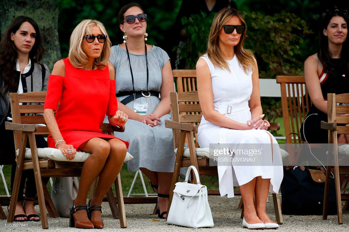 Trong ngày thứ 2 của chuyến công du, Melania Trumptới thăm ngôi làng truyền thống Basque ở Espelette (gần Biarritz, Pháp). Tại đây, Đệ nhất phu nhân Mỹ chọn cho mình thiết kế trắng tinh khôi với điểm nhấn là thắt lưng, túi xách Hermes và giày bệt màu sắc đồng điệu. Chiếc túi Hermes đắt đỏ thay vì nâng niu ôm trên người, phu nhân Mỹ bỏ xuống đất ngồi khoan thai.