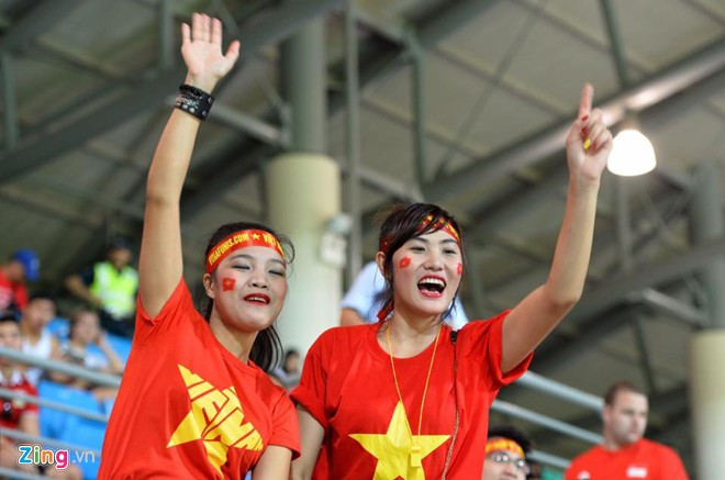 Đỗ Thị Hương (phải), sinh viên người Việt Nam đang học tại Singapore rủ bạn (bên trái) là người Philippines đi cổ vũ bóng đá.