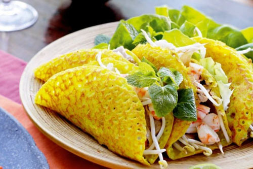 Bánh xèo Quảng Hòa: Loại bánh xèo làm bằng gạo đỏ (gạo lứt) với hoa văn nổi, đơn giản nhưng phải đủ các món kèm theo như cá chuối, nộm, rau sống, bánh đa và nước chấm. Đĩa nộm gồm có giá, rau két và vừng. Khi ăn, lấy bánh xèo cuốn rau sống, nộm, cá chuối lại rồi kẹp vào bánh đa. Bánh xèo ăn ngon nhất là lúc vừa tráng xong, bánh vừa nóng hổi mùi thơm gạo lứt vừa sần sật nộm rau sống, bánh đa. Ảnh: Internet.