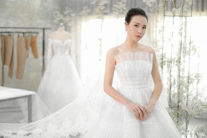 Cô dâu Đàm Thu Trang vốn sở hữu vóc dáng mảnh mai, gương mặt xinh đẹp cuốn hút nên chỉ cần áp dụng lối trang điểm tự nhiên và kiểu tóc búi cao gọn gàng đã đủ để cô tỏa sáng trong ngày trọng đại. Ảnh: Saostar.