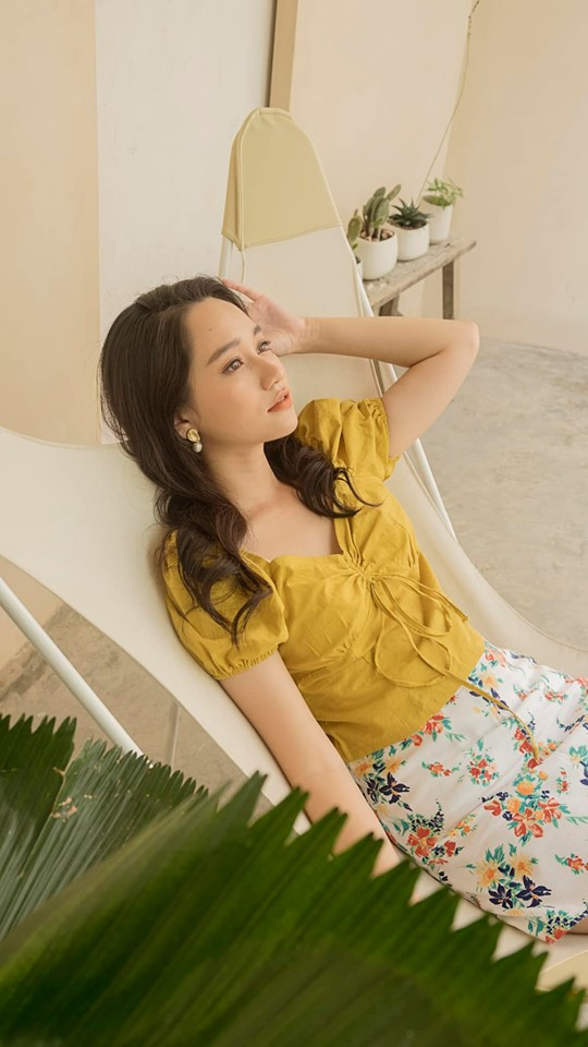 Cô phối váy hoa với áo vàng nổi bật.