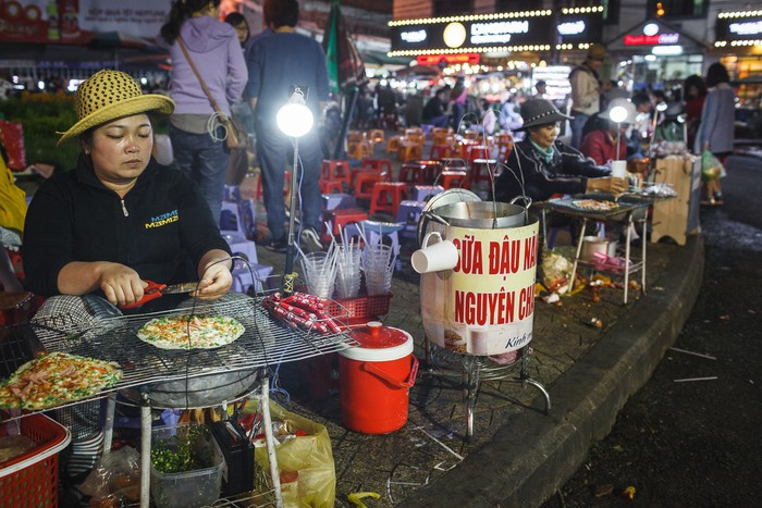 Bánh tráng nướng được coi là món ăn vặt số 1 tại chợ đêm Đà Lạt. Những chiếc bánh vừa ra lò nóng hổi chắc chắn sẽ làm ấm bụng du khách trong tiết trời se lạnh tại Đà Lạt. Ảnh: Zing.