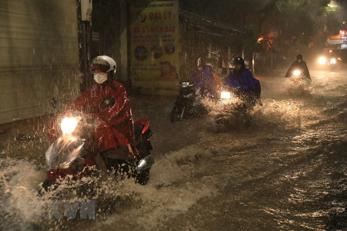 Phố Khương Hạ ngập khiến nhiều người đi lại khó khăn. (Ảnh: Tuấn Anh/TTXVN)