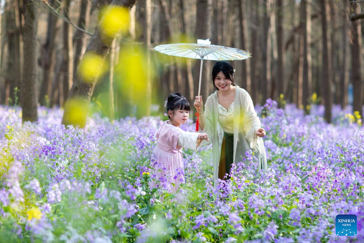 Hai mẹ con đang chơi đùa trong vườn hoa tại công viên ở thành phố Xinghua, tỉnh Giang Tô.
