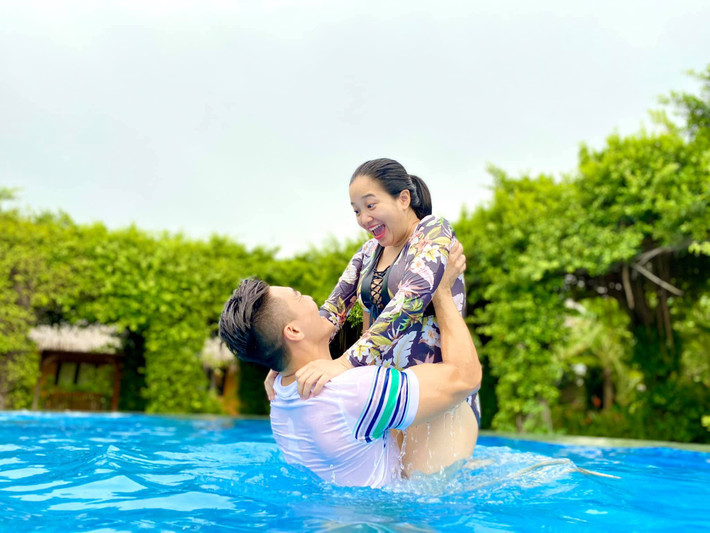 Nghệ sĩ xiếc Quốc Cơ cùng bà xã - MC Hồng Phượng khoe khoảnh khắc hạnh phúc vui đùa dưới bể bơi. "Lâu lâu cho đôi tình nhân lên sóng. Chụp được vài tấm rồi quay qua bế con ngay dù là tình nhân nhưng không quên nhiệm vụ", bà xã anh viết.