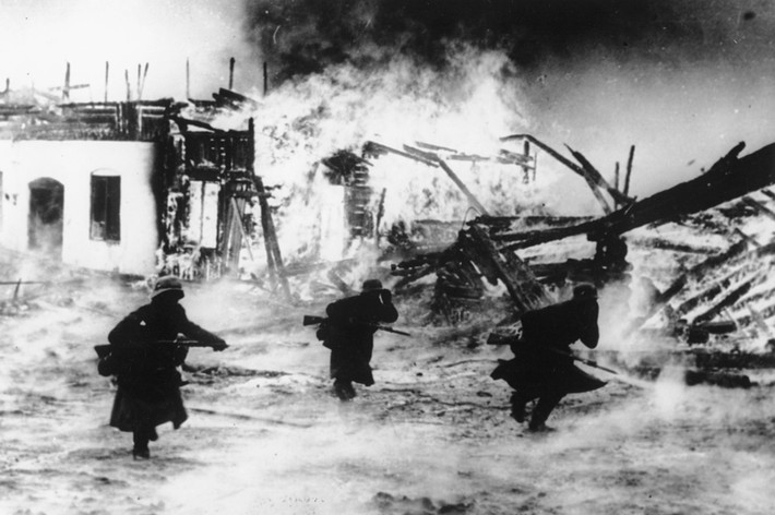 Một nhóm binh sĩ phát xít Đức đi qua một ngôi làng ở Na Uy bị thiêu rụi tháng 4/1940. Đây là một trong những quốc gia bị Đức quốc xã tấn công và chiếm đóng.