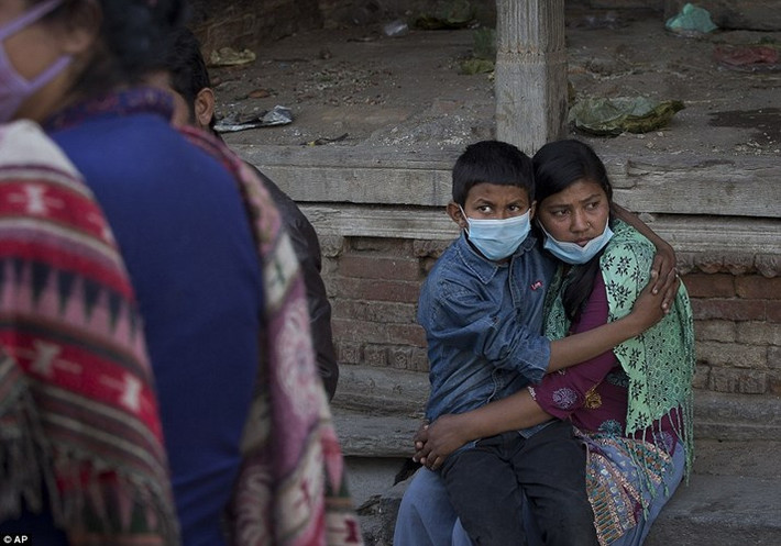 Monika Basnet, 15 tuổi, đang ôm chặt em trai Munal, 10 tuổi, trong suốt lễ hỏa táng thi thể của người cha ở đền Pashupatinath. Cha của hai người là một trong hàng ngàn nạn nhân thiệt mạng do động đất (Ảnh: AP)