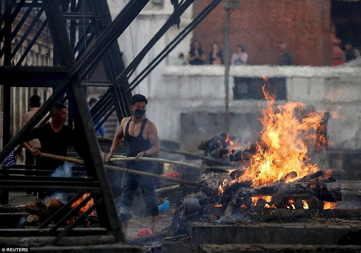 Các khúc gỗ dùng làm giàn hỏa táng được đốt cháy cùng với thi thể nạn nhân (Ảnh: Reuters)