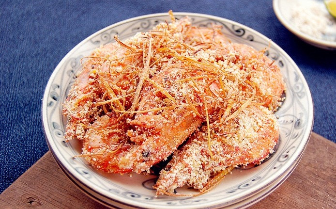 Trộn bột muối với 50 bột gạo nếp, 20g bột đậu xanh rang chín sao đó trút toàn bộ số tôm đã chiên vào đảo cho bột phủ đều quanh con tôm. Cuối cùng đổ đĩa gừng, sả đã chiên vào đảo đều tiếp trong khoảng 5 phút là có thể thưởng thức. Ảnh: Bepgiadinh.