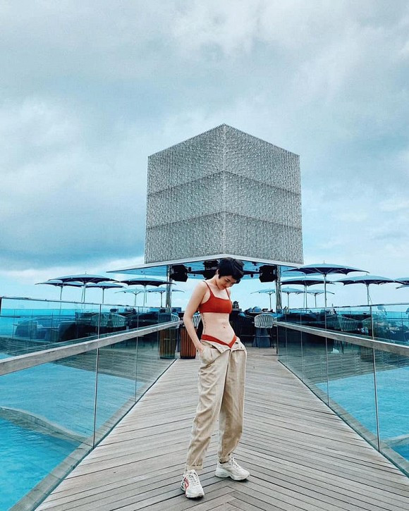 Trong chuyến đi du lịch sau Tết nguyên đán 2020, Bảo Anh cũng mix bikini màu đỏ kết hợp cùng quần ống rộng phanh cúc, phô diễn eo phẳng lì.