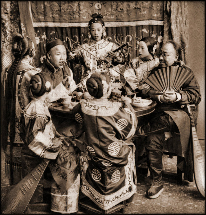 Hai thương nhân giàu có vừa ăn uống vừa nghe các cô gái đàn hát ở Bắc Kinh năm 1901.
