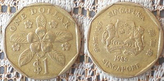 Đồng 1 đôla Singapore. Theo một số tài liệu ghi nhận, khoảng những năm 1980, khi việc xây dựng đường tàu điện ngầm gặp nhiều khó khăn, Thủ tướng Lý Quang Diệu đã nhận được một lời khuyên về phong thủy để cho ra đời đồng một đôla Singapore. Đồng tiền với biểu tượng bát quái ở gần mép ngoài được đa số người dân nước này mang theo bên mình với niềm tin đây chính là tín vật linh thiêng. Với họ, nó không chỉ mang ý nghĩa tâm linh mà còn là biểu tượng tài khí. (Ảnh: Kinhnghiemsingapore)
