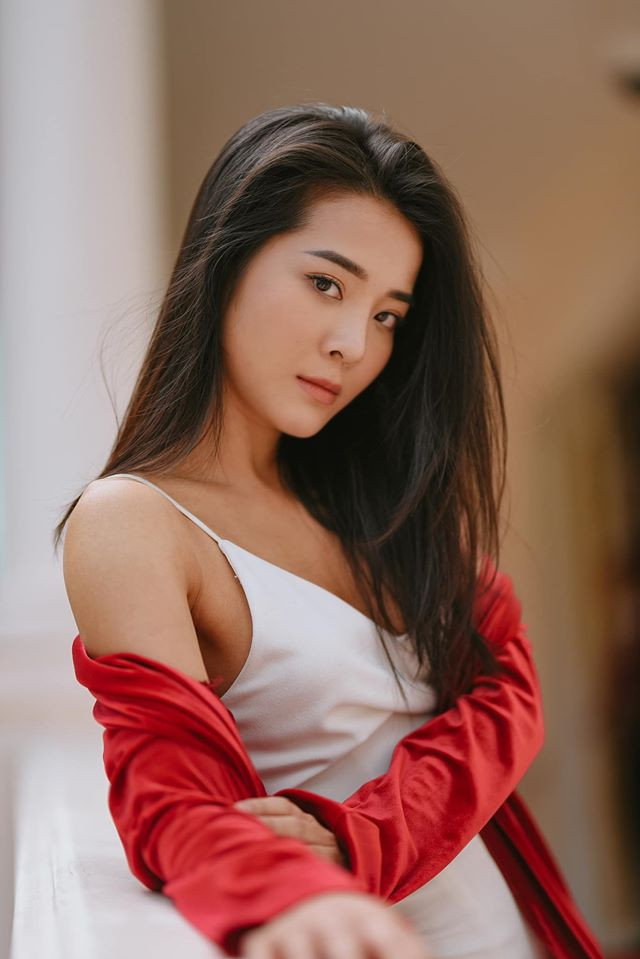 Karen cuốn hút với chiếc đầm trắng hai dây phối cùng áo khoác đỏ nổi bật.