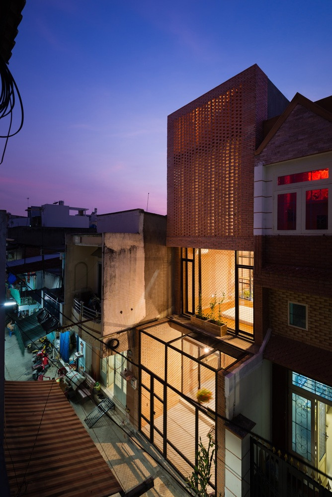 Cổng và hàng rào của ngôi nhà được thiết kế đơn giản với lưới tản nhiệt kim loại để trồng những cây nho dây leo. Đội ngũ thiết kế muốn mang lại một không gian sống tươi sáng và sống động đến khu phố này.