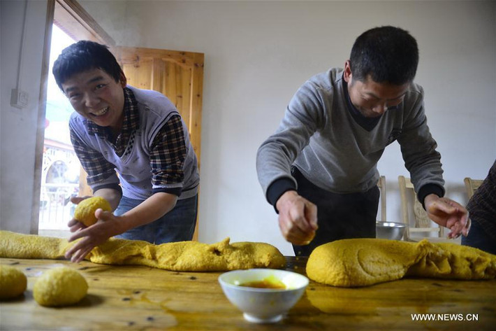 Dân làng ở Ganxian County, tỉnh Giang Tây, đang làm "miguo", một loại bánh làm bằng gạo nếp và nhuộm bằng hoa sophorae để đón Tết.
