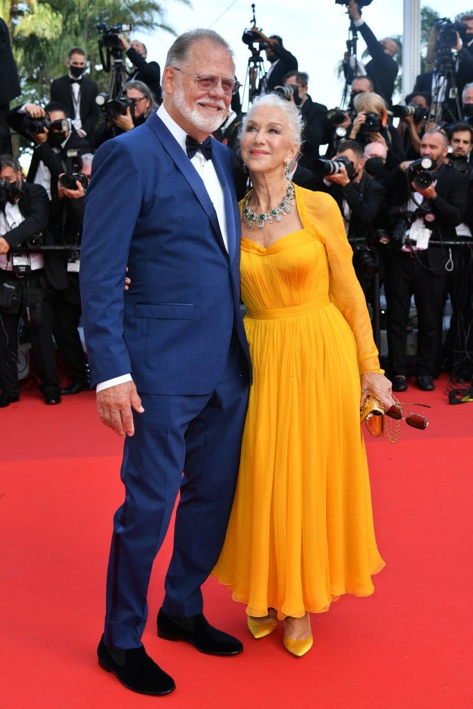 Minh tinh gạo cội Helen Mirren được chồng Taylor Hackford hộ tống lên thảm đỏ Liên hoan phim. Giữa dàn sao trẻ đẹp, Mirren vẫn nổi bật với chiếc váy vàng có điểm thắt keo, được kết hợp cùng clutch hiệu Dolce & Gabbana và vòng cổ nạm đá quý.
