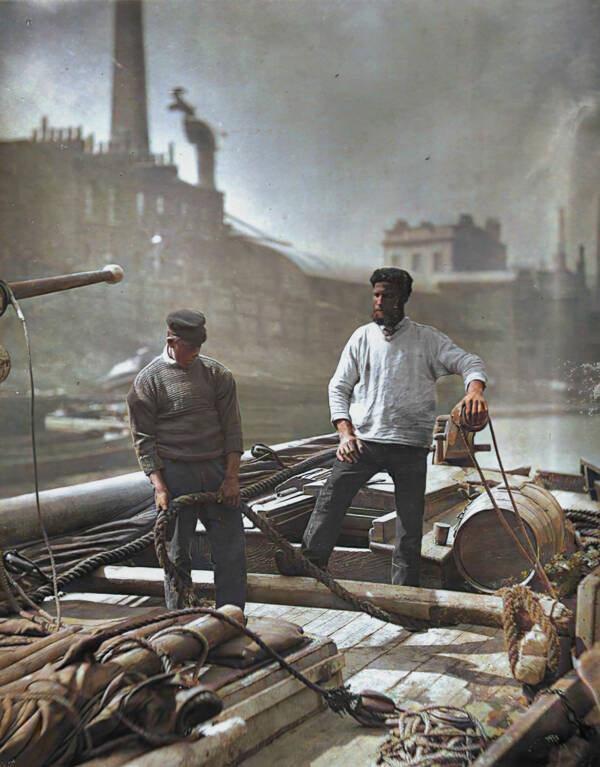 Hai người đàn ông làm việc trên một con thuyền ở sông Thames, thủ đô London, Anh năm 1877.