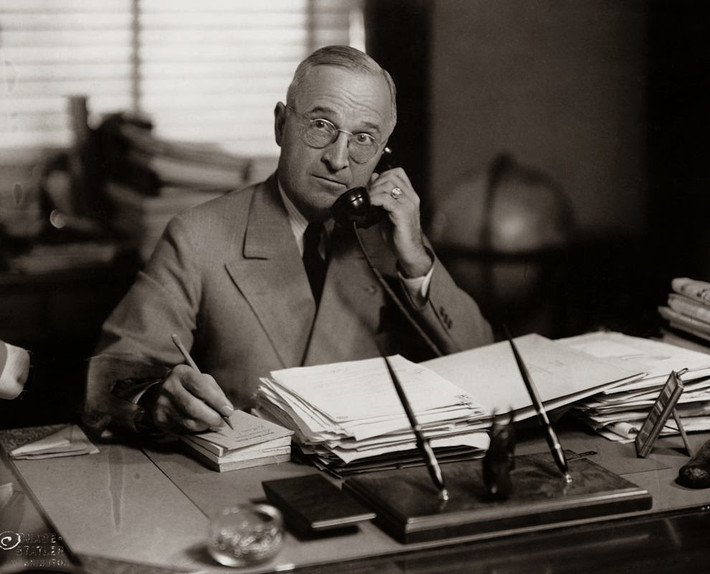 Tổng thống Harry Truman vừa gọi điện thoại vừa viết những điều quan trọng ra giấy. Ảnh chụp tại văn phòng ở Nhà Trắng năm 1945.