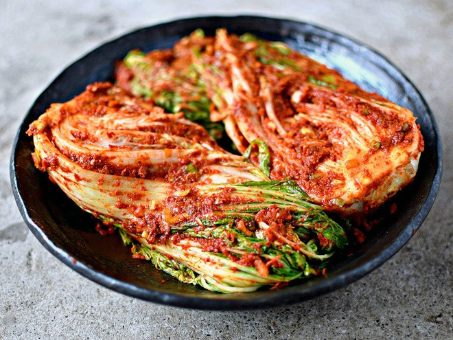 Kim chi xuất hiện ở Hàn Quốc vào khoảng thế kỷ thứ 7. Kim chi truyền thống được chế biến từ cải thảo và nước muối. Vào thế kỷ 12, để tạo thêm sự đa dạng cho hương vị, thành phần kim chi có chút thay đổi như vị chua ngọt, và màu sắc. Hiện tại, hơn 200 loại kim chi khác nhau như kim chi bắp cải, kim chi cải bẹ xanh, kim chi hẹ, kim chi dưa leo, kim chi lá mè, kim chi cải non, kim chi rau diếp, kim chi củ cải muối… Năm 2013, kim chi Hàn Quốc được UNESCO công nhận là di sản văn hóa và xếp vào top 5 loại thực phẩm tốt nhất cho sức khỏe. Vì thế, Hàn Quốc được cả thế giới gọi là xứ sở của kim chi.