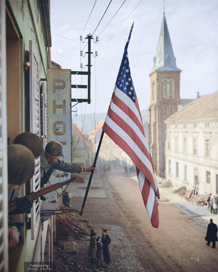 Binh sĩ Mỹ cắm cờ trên một tòa nhà ở Pháp sau khi giải phóng nơi này tháng 3/1945. Lá cờ này do một cô gái ở một cửa hàng tại Bitche, Pháp bí mật làm ra.