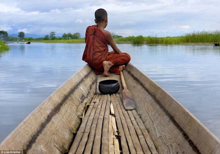 Một cậu bé hướng tầm nhìn ra xa khi ngồi trên thuyền tại một dòng sông ở Myanmar.