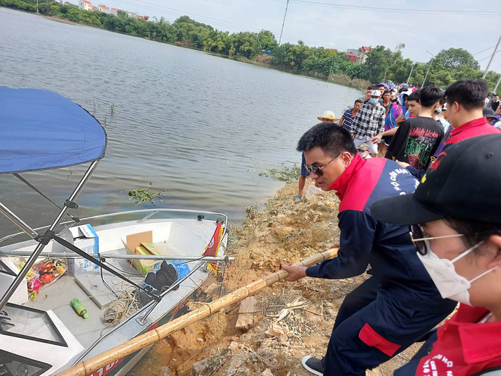 Đội cứu hộ được người dân cung cấp sào tre để hỗ trợ chuyển ca nô xuống nước.