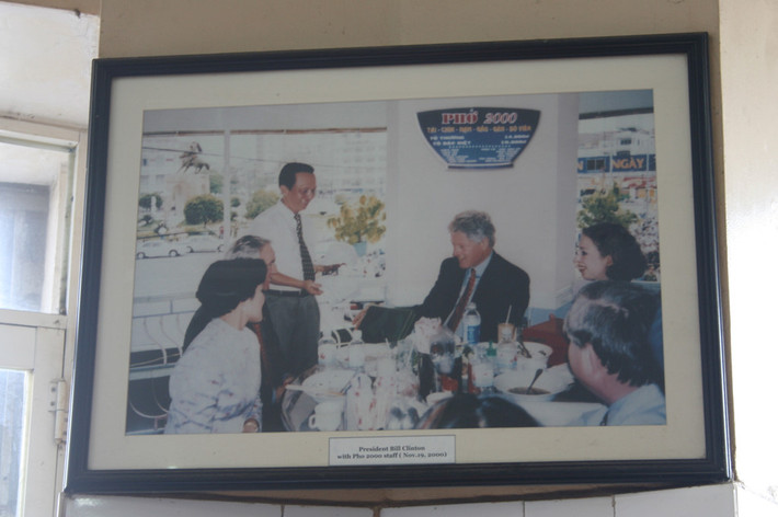 Trong chuyến thăm hữu nghị Việt Nam năm 2000, gia đình cựu Tổng thống Mỹ Bill Clinton đã ghé quán phở sát chợ Bến Thành (TP.HCM) để thưởng thức phở bò, sau đó thân thiện lưu lại ảnh kỷ niệm với nhân viên cửa hàng. Ảnh: Vietnamtrip.