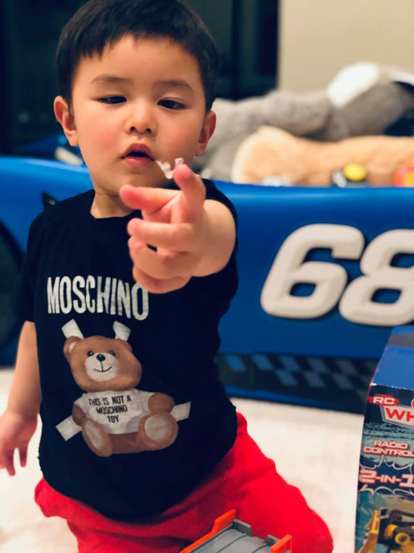 Cậu bé 2 tuổi ăn mặc sành điệu và không ít món đồ là hàng hiệu như chiếc áo hiệu Moschino có giá vài triệu đồng.