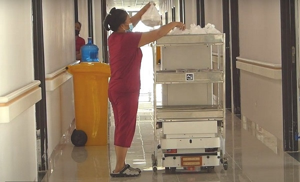 Khi triển khai ở TP HCM, nhóm nghiên cứu đã thiết lập cơ sở hạ tầng để robot hoạt động, hỗ trợ chăm sóc, điều trị F0. Mỗi Vibot có thể mang 60 kg vật dụng, thực phẩm tương ứng với khoảng 60 suất ăn, còn sức kéo của robot là 100 kg. Sau khi bệnh nhân đã nhận xong đồ ăn, robot Vibot sẽ nói: "Xin cảm ơn" và "Tạm biệt". Ảnh: dangcongsan.