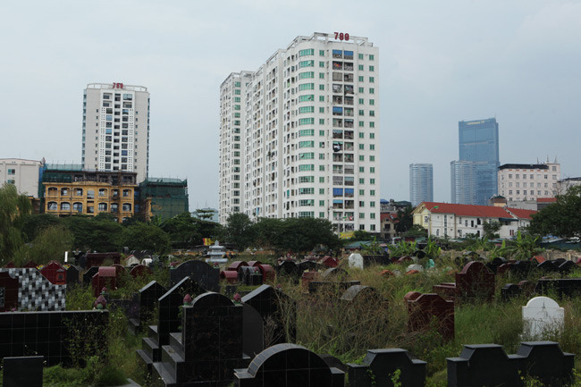 Một tòa nhà chung cư cao tầng sát nghĩa trang, phía xa là tòa nhà cao nhất Việt Nam - Keangnam Landmark 72.