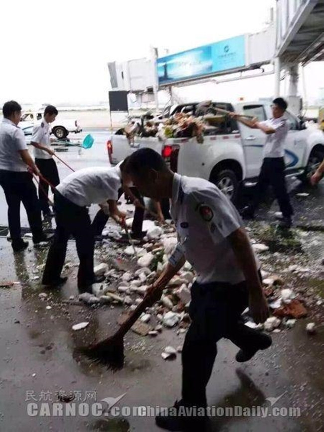 Nhân viên sân bay dọn dẹp những đống đổ nát sau cơn bão.