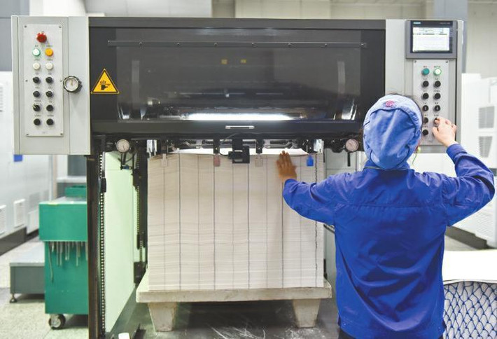 Một công nhân điều khiển máy in tiền.
