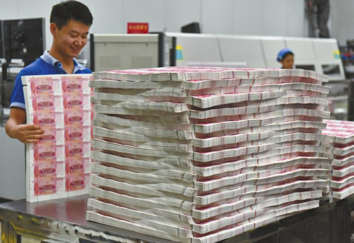 Một công nhân xử lý những xấp tiền giấy trong nhà máy in tiền Thành Đô ở thành phố Thành Đô, tỉnh Tứ Xuyên, Trung Quốc.