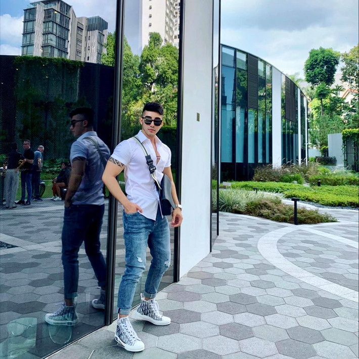 Anh phối áo sơ mi trắng với quần jeans rách gối năng động xuống phố.
