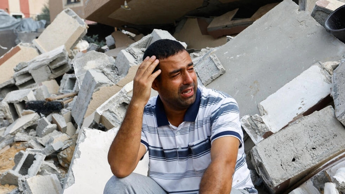 Một người đàn ông Palestine ngồi cạnh đống đổ nát của một ngôi nhà bị phá hủy trong cuộc không kích vào Gaza của Israel ở Khan Younis, phía nam Dải Gaza vào ngày 8/10. Ảnh: Reuters.