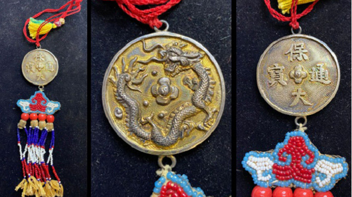 Đồng tiền thời vua Bảo Đại (1926 - 1945), bạc mạ vàng, trên mặt sau có 4 chữ Hán nghĩa là “Đồng tiền hiện tại của Bảo Đại”. Mặt còn lại của đồng tiền có một con rồng cuộn tròn, bảo lãnh được hàn ở trên cùng và dưới cùng, với các tua bằng sợi tơ và ngọc trai và dây. Cổ vật này được Millon bán đấu giá cùng với nhiều hiện vật thời nhà Nguyễn khác.