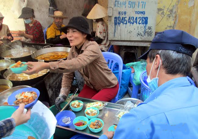 Nằm trong con ngõ Võng Thị trên đường Lạc Long Quân (Tây Hồ, Hà Nội), quán bánh rán của chị Nguyễn Thị Mai Hoa luôn đông nghịt khách. Thậm chí, khách còn phải lấy số thứ tự xếp hàng đợi mua như thời bao cấp. Ảnh: Vietnamnet.