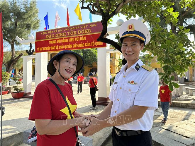 Bà Hoàng Thị Lai, kiều bào Thái Lan trong Đoàn công tác số 4 ra thăm Trường Sa, vui mừng khi chụp ảnh cùng với một chiến sỹ.