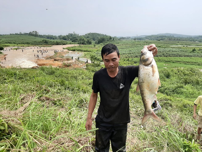 Người đàn ông và cá bắt được sau sự cố vỡ đập.
