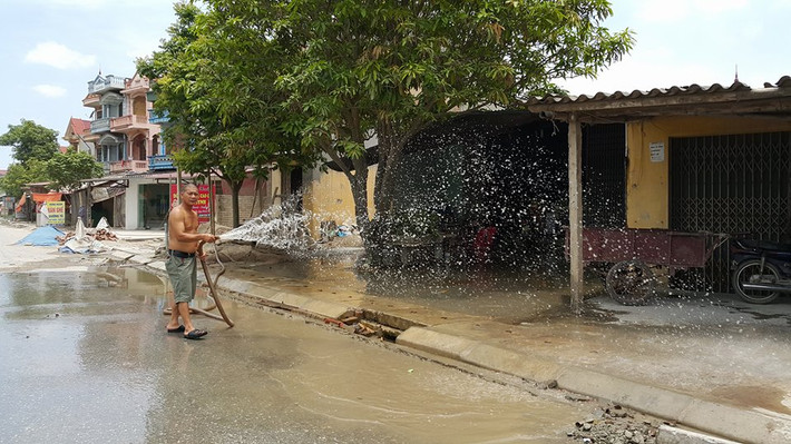 Nhiều hộ dân đã phải ra tưới nước giữa trời nắng nóng nhưng tình trạng bụi không thuyên giảm.