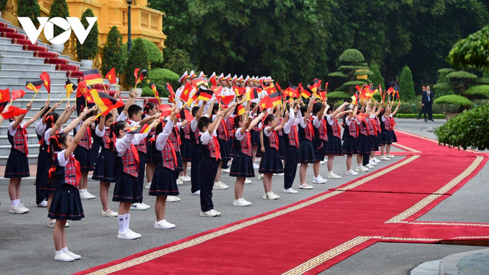 Các em thiếu nhi vẫy cờ hai nước chào đón Thủ tướng Olaf Scholz.