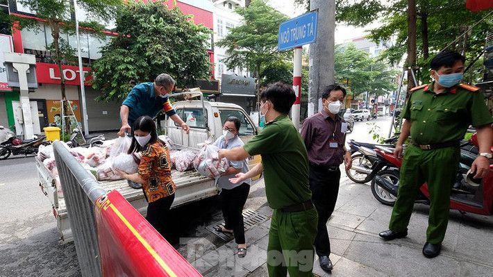 Các lực lượng chức năng vận chuyển hàng hóa nhu yếu phẩm cung cấp cho những hộ dân có hoàn cảnh khó khăn cần trợ giúp trong khu vực phong tỏa cách ly y tế.