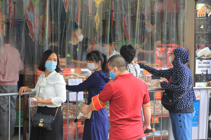 Người của cơ sở sản xuất bánh trung thu này liên tục yêu cầu người dân đứng đúng vị trí, giữ khoảng cách, đảm bảo an toàn phòng chống dịch.
