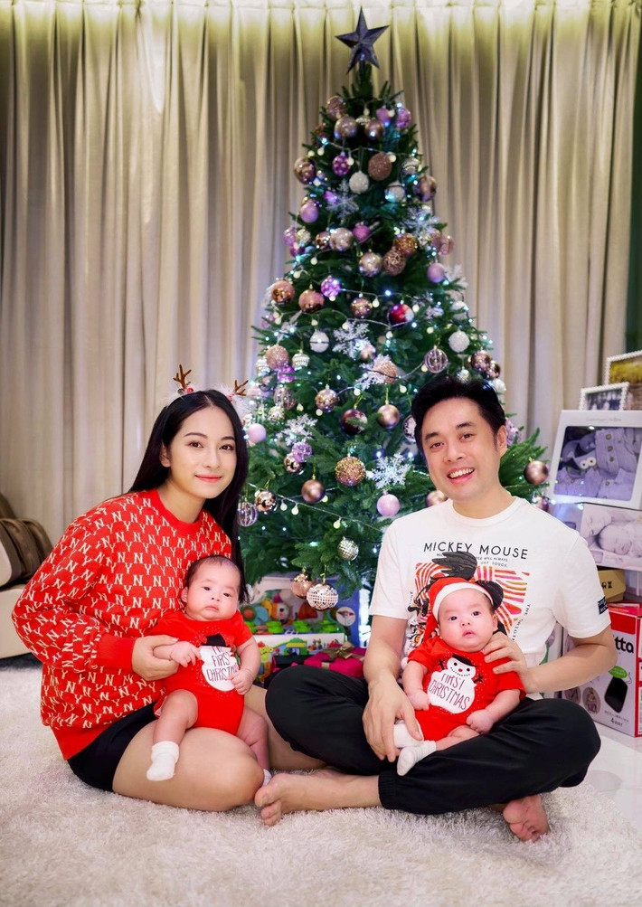 Dương Khắc Linh cùng Sara Lưu chụp ảnh kỷ niệm cùng hai con bên cây thông Giáng sinh được trang trí rực rỡ. Cả nhà diện đồ với tông màu đỏ - trắng.