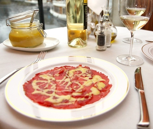 Bên trên, người ta sẽ rưới thêm chút dầu ô liu, chanh và để trong tủ lạnh. Carpaccio thường được dùng vào mùa hè, thích hợp khi khí hậu oi bức. Tên món ăn xuất hiện lần đầu tại thành phố Venice để tưởng nhớ họa sỹ Vittore Carpaccio.