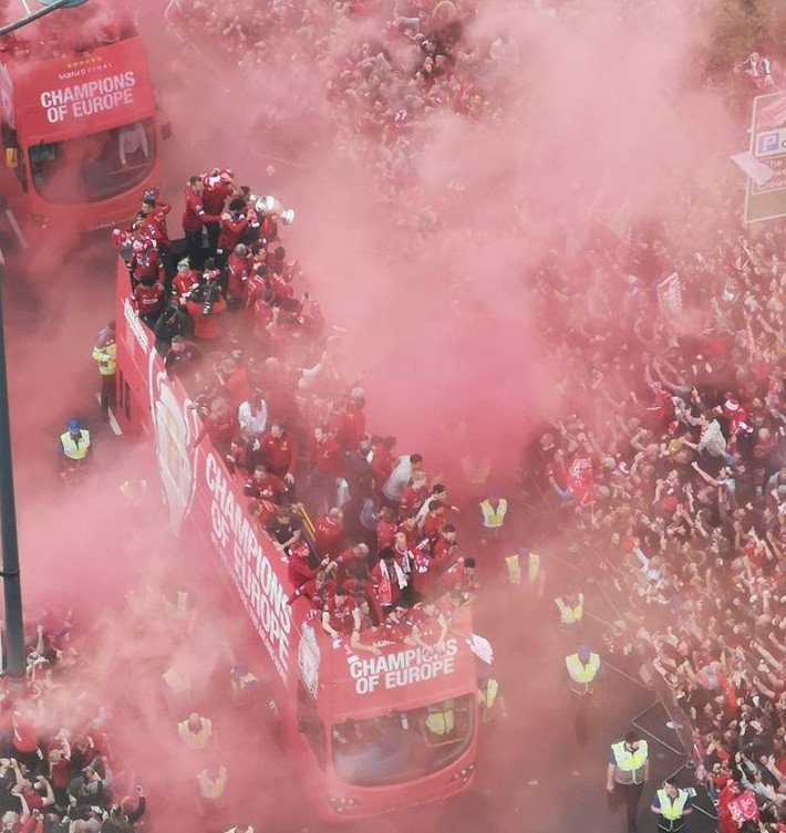 Xe buýt của Liverpool từ từ lướt qua làn sương khói mờ ảo do người hâm mộ tạo ra.