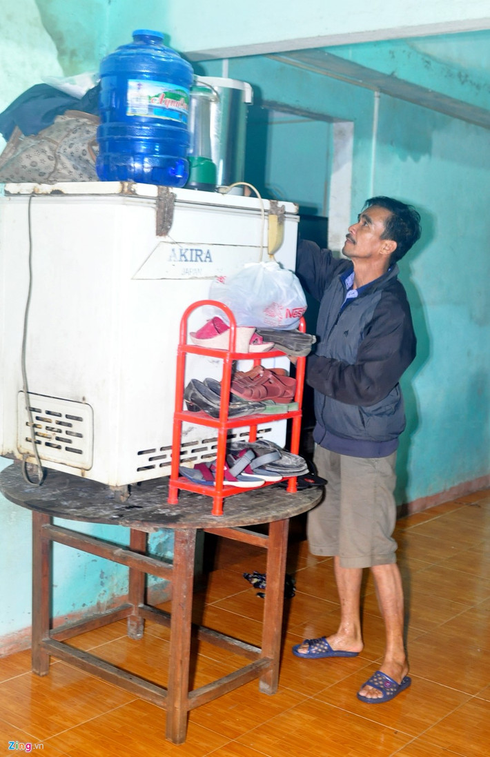 Ông Đặng Văn Thành (ngụ xã Nghĩa Phương) kê tủ lạnh cùng một số đồ dùng sinh hoạt lên bàn tránh lũ.