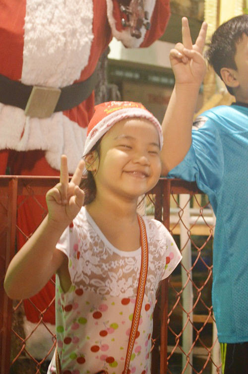 Một bé gái thích thú chụp hình kỉ niệm mùa Noel